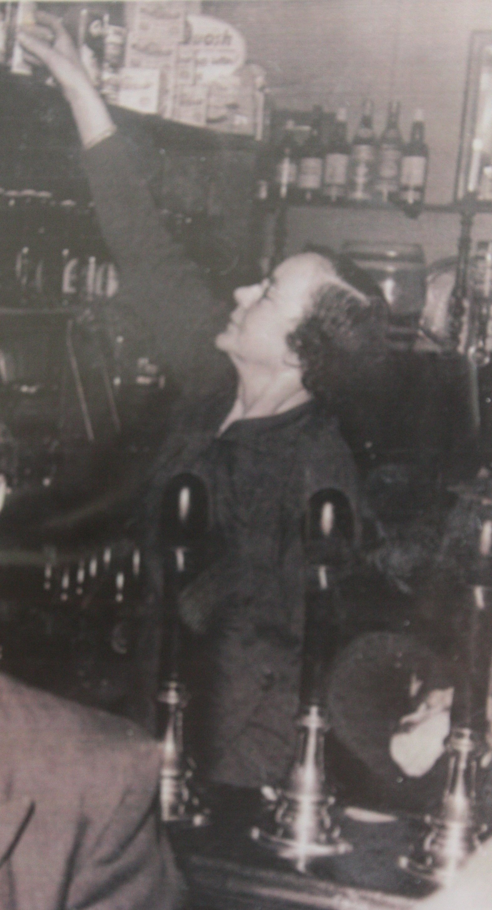 Landlady Elsie Ayres working behind the bar of the Farriers Arms